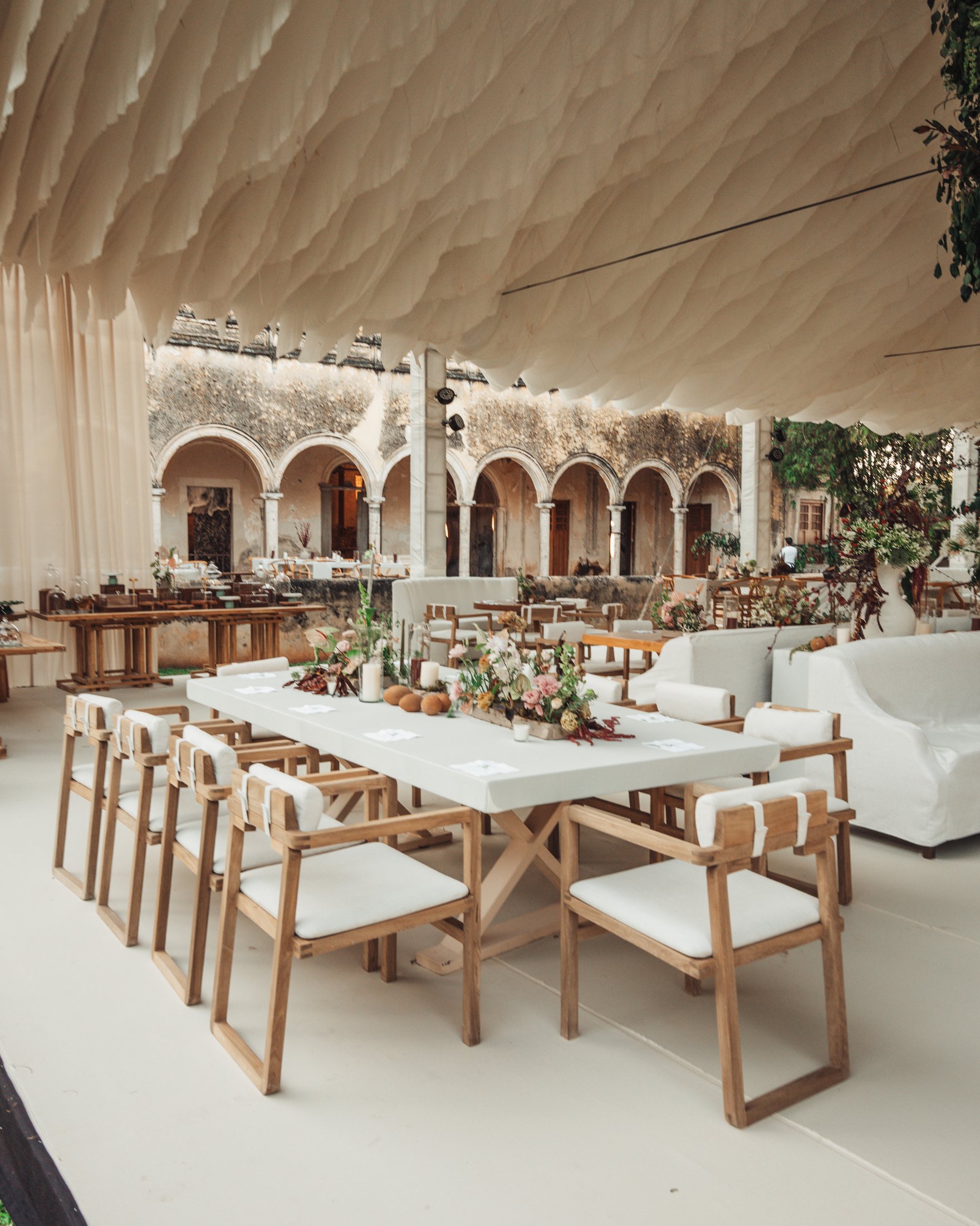 Mesas, sillas y salas blancas montadas para una celebración en una hacienda de Yucatán