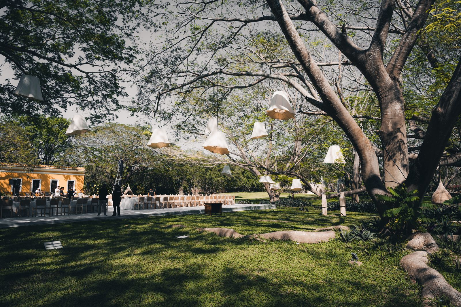 Jardín con mesas y luminarias suspendidas