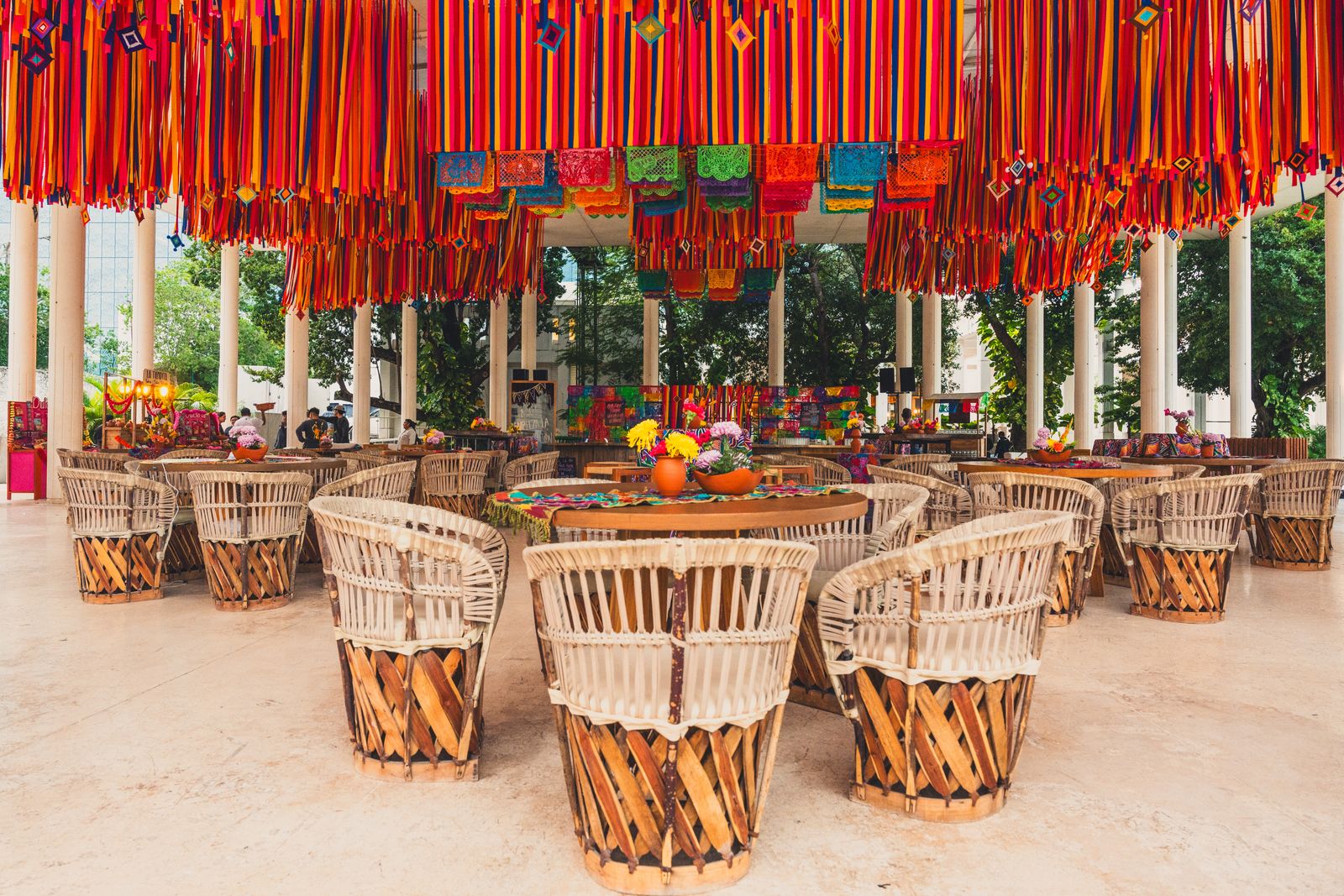 Comedor con sillas de fibras naturales bajo papel picado
