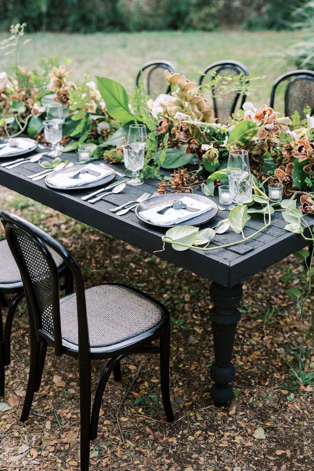 Detalle de la mesa carbón con vajilla y flores